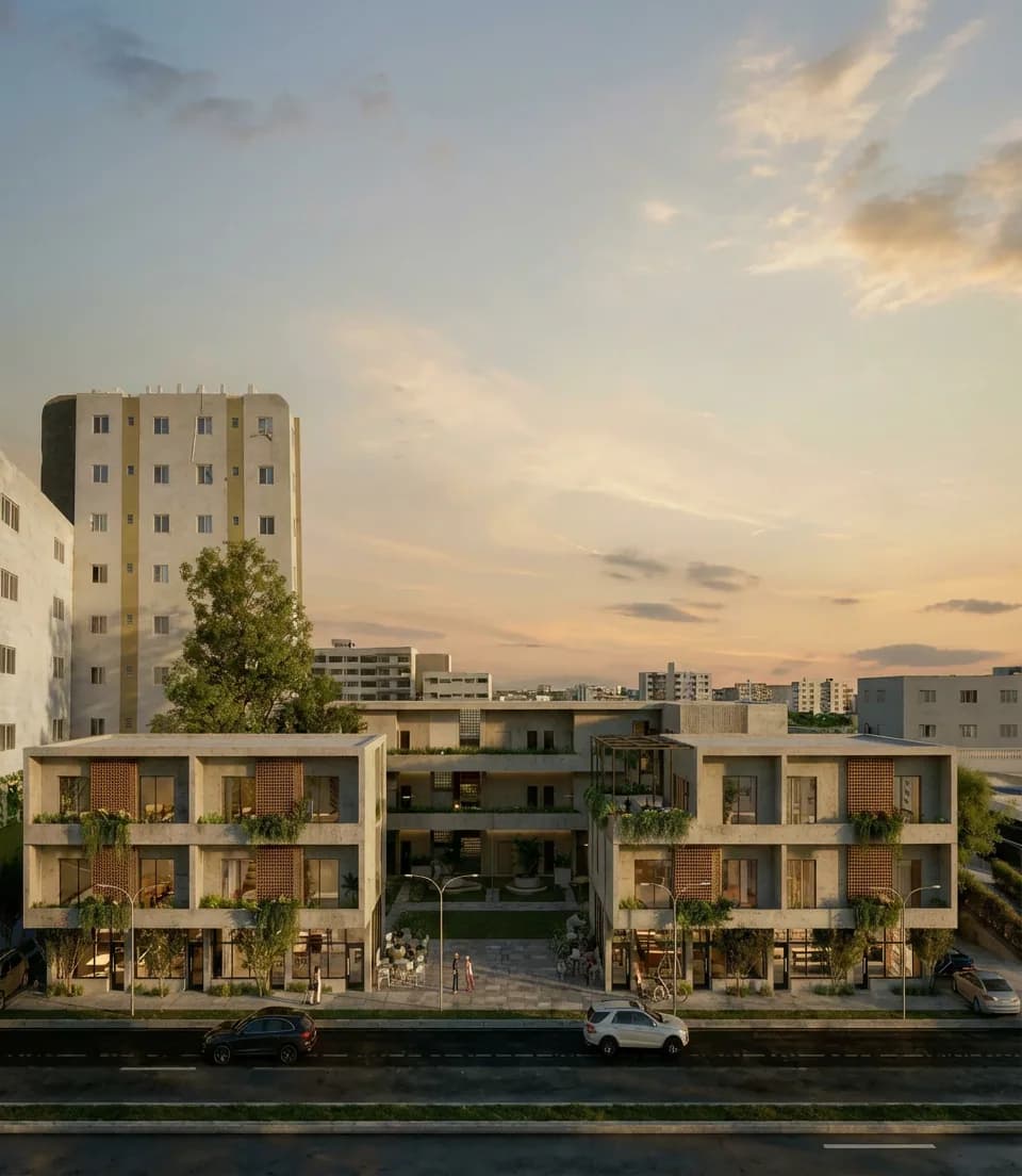 Vista frontal del edificio Distrito 919 al atardecer con fachada de ladrillo claro y balcones vegetados